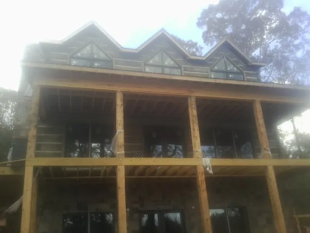 Dormers and porch framing on a large log home under construction — Roof Coating work by our crew in Idaho Springs