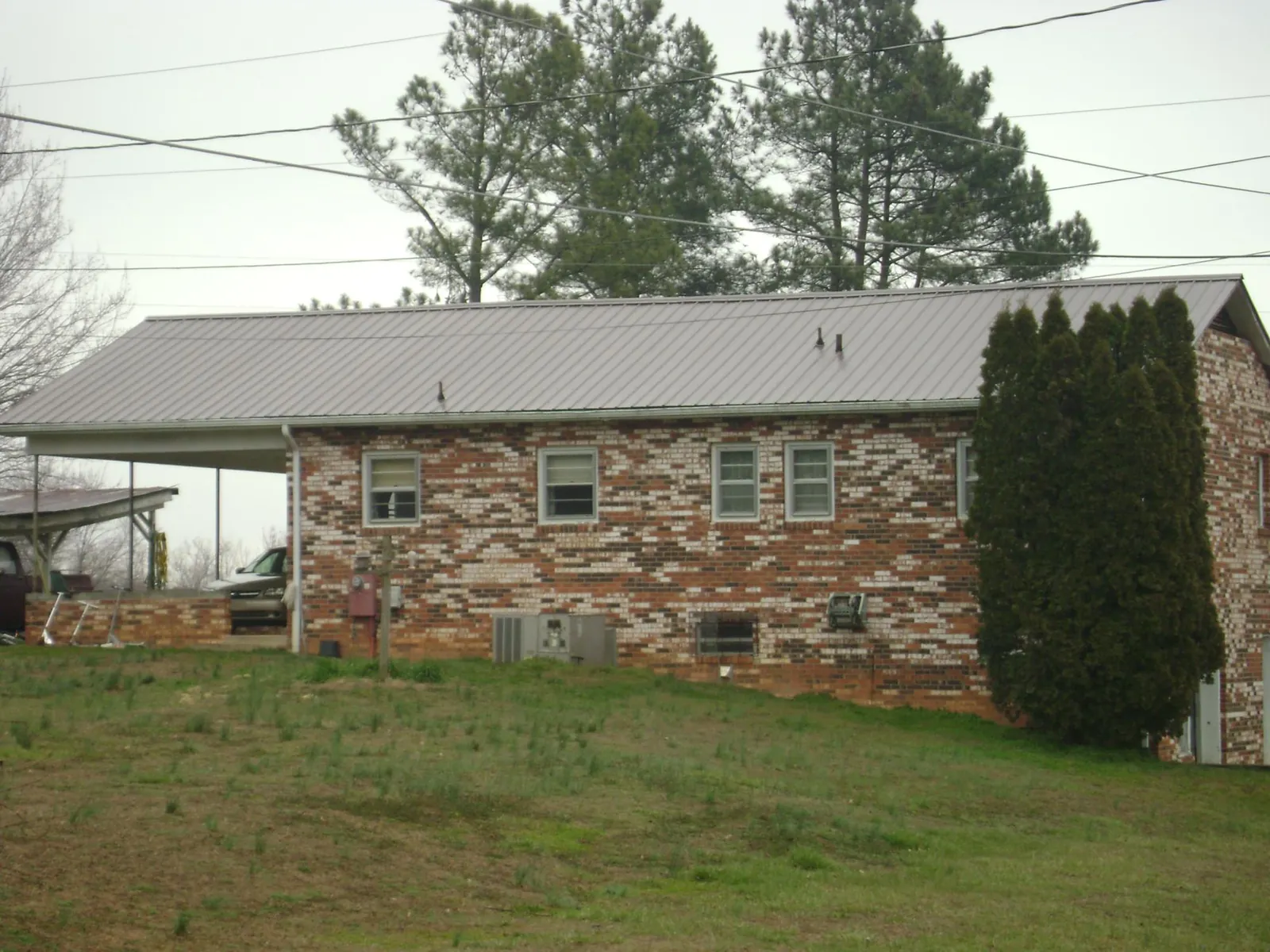 Gray metal roof on a brick split level home with a carport in Idaho Springs