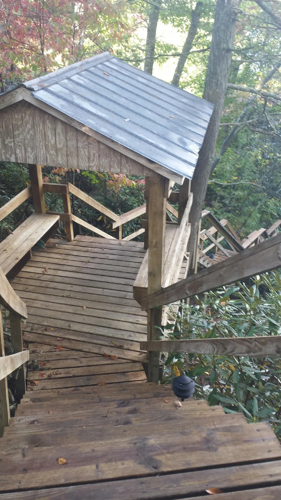 Metal roofed shelter over wooden steps on a wooded walkway — Skylight Repair & Installation work by our crew in Idaho Springs