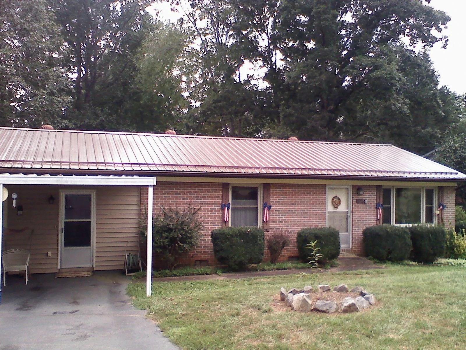 Bronze metal roof and carport on a brick ranch home — Roof Repair work by our crew in Idaho Springs